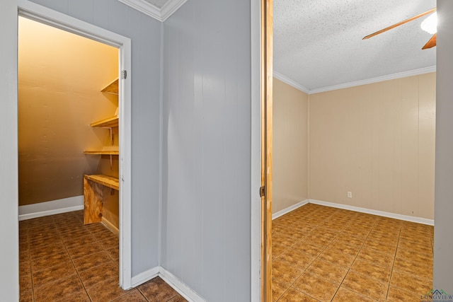 hall with a textured ceiling and crown molding