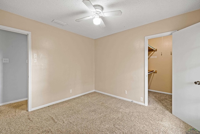 carpeted empty room featuring ceiling fan and a textured ceiling