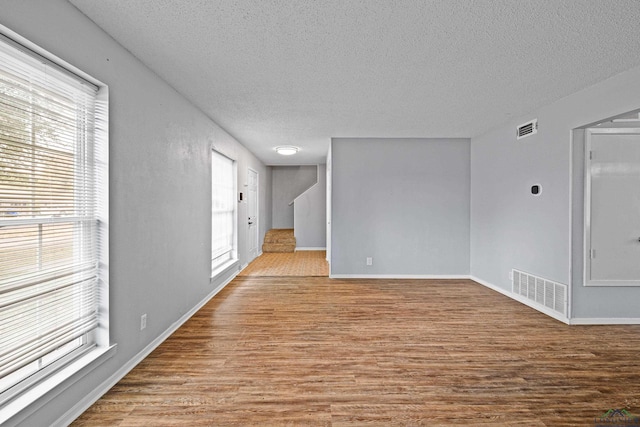 unfurnished room featuring a textured ceiling and light wood-type flooring