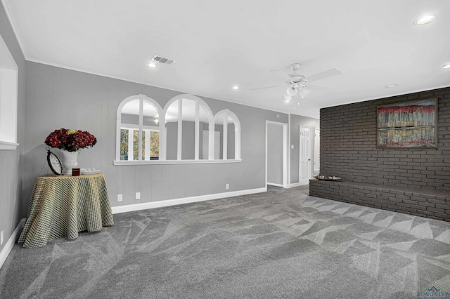 unfurnished living room featuring ceiling fan, crown molding, and carpet floors