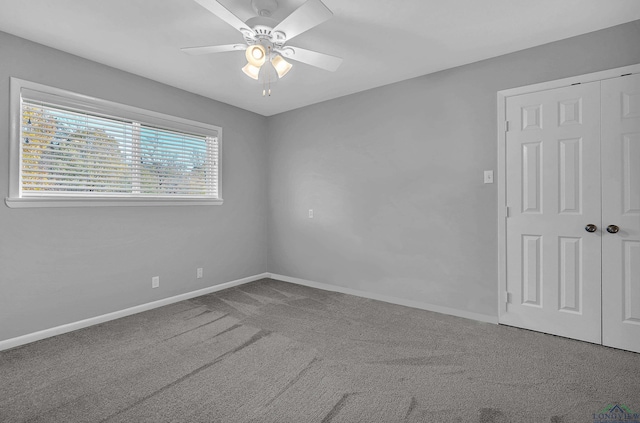 carpeted spare room featuring ceiling fan