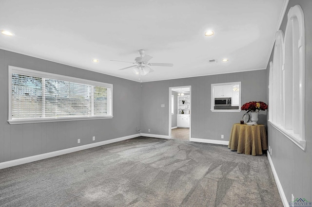 unfurnished living room with carpet flooring, ceiling fan, and ornamental molding