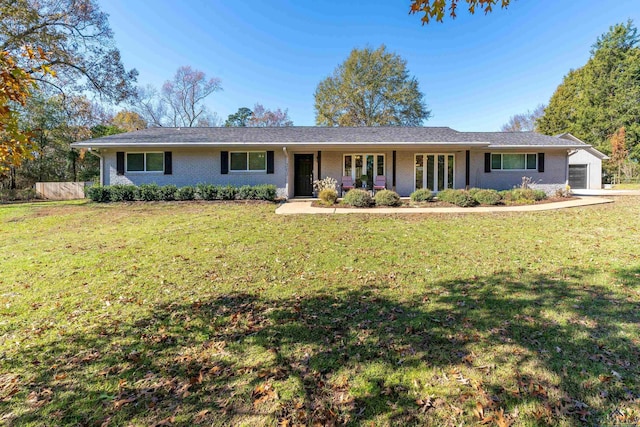 ranch-style house with a front yard, a garage, and covered porch