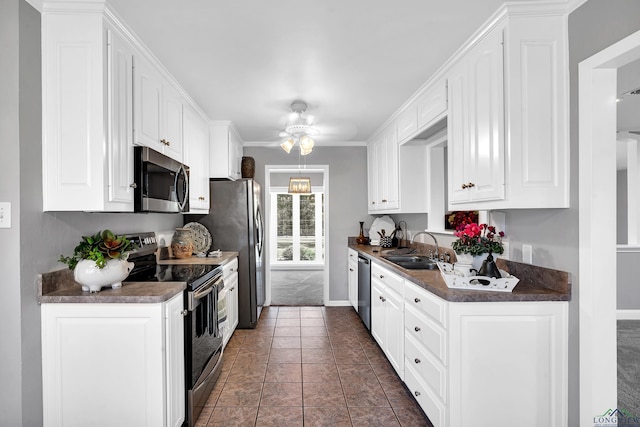 kitchen with white cabinets, sink, ceiling fan, dark tile patterned floors, and stainless steel appliances