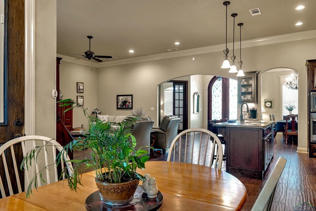 1624 Olympic Dr, Longview, TX 75605 - dining area featuring arched walkways, a ceiling fan, recessed lighting, crown molding, and dark wood-type flooring