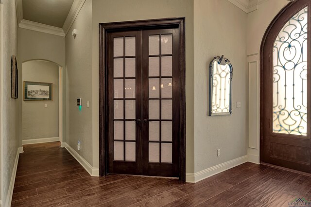 1624 Olympic Dr, Longview, TX 75605 - foyer featuring french doors, crown molding, arched walkways, dark wood-style floors, and baseboards