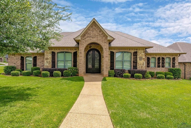 1624 Olympic Dr, Longview, TX 75605 - french country style house featuring brick siding, roof with shingles, and a front yard