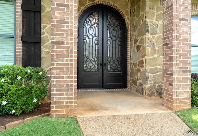 1624 Olympic Dr, Longview, TX 75605 - property entrance featuring brick siding, concrete driveway, and french doors