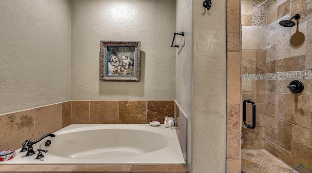 1624 Olympic Dr, Longview, TX 75605 - full bathroom featuring a textured wall, a stall shower, and a bath