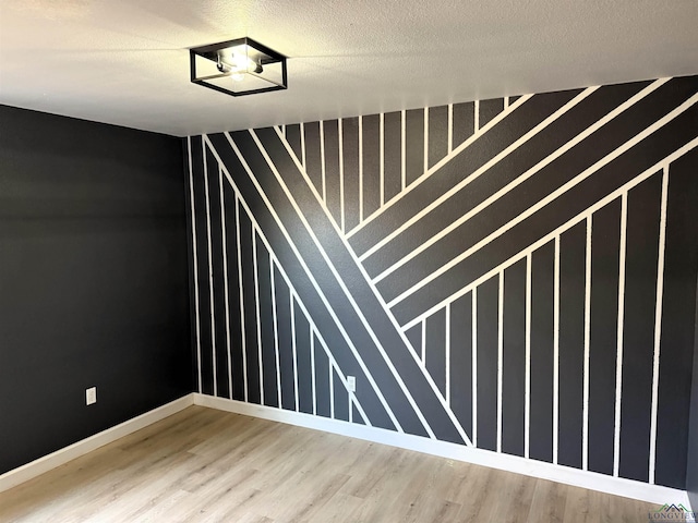 spare room featuring a textured ceiling and hardwood / wood-style flooring