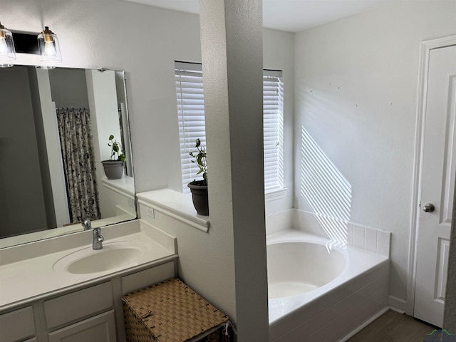 bathroom with a relaxing tiled tub and vanity