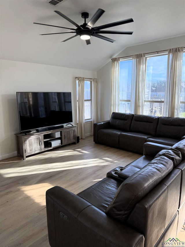 living room featuring ceiling fan, lofted ceiling, and light hardwood / wood-style floors