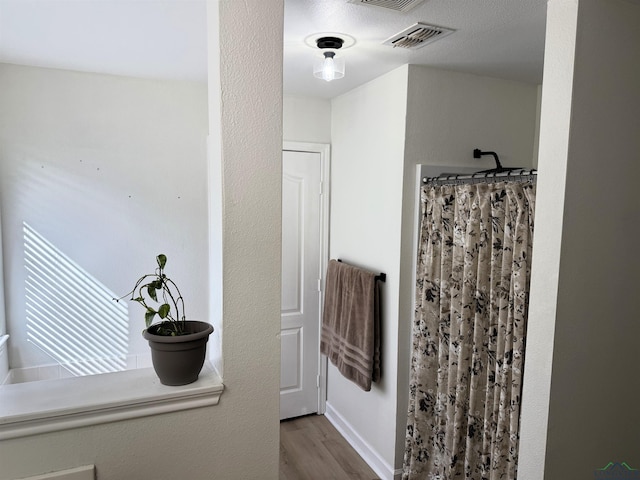 bathroom with walk in shower and hardwood / wood-style floors