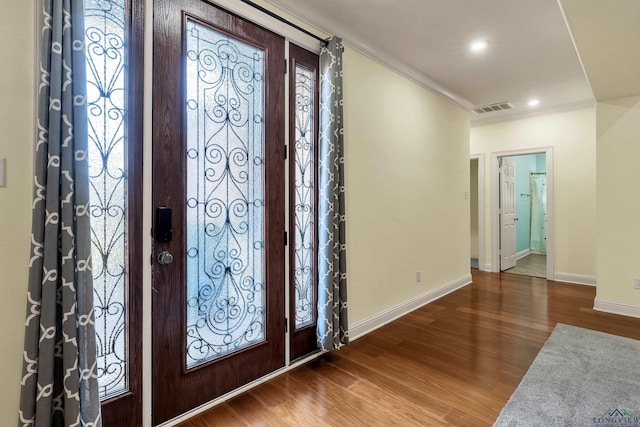 entrance foyer featuring a healthy amount of sunlight, hardwood / wood-style flooring, and crown molding