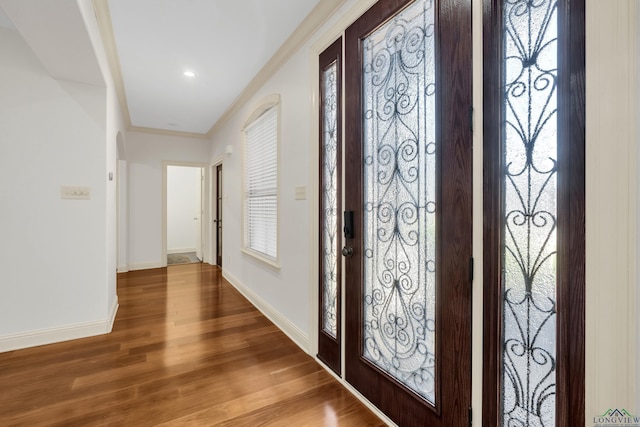 foyer entrance featuring crown molding, baseboards, a wealth of natural light, and wood finished floors