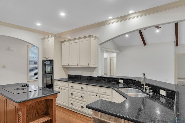 kitchen featuring arched walkways, dobule oven black, a sink, light wood finished floors, and electric stovetop