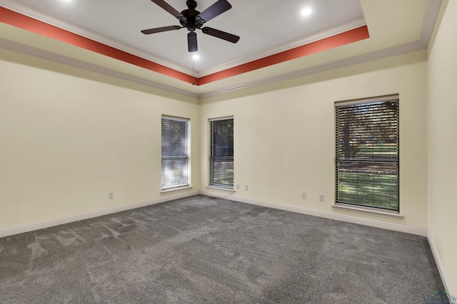 carpeted empty room featuring ceiling fan, a raised ceiling, and crown molding