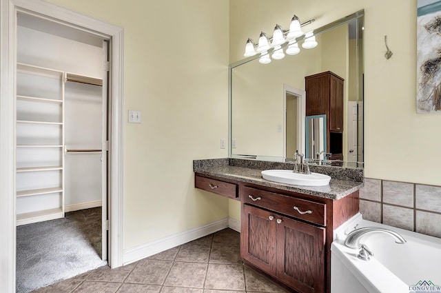 bathroom featuring tile patterned flooring, vanity, and a tub