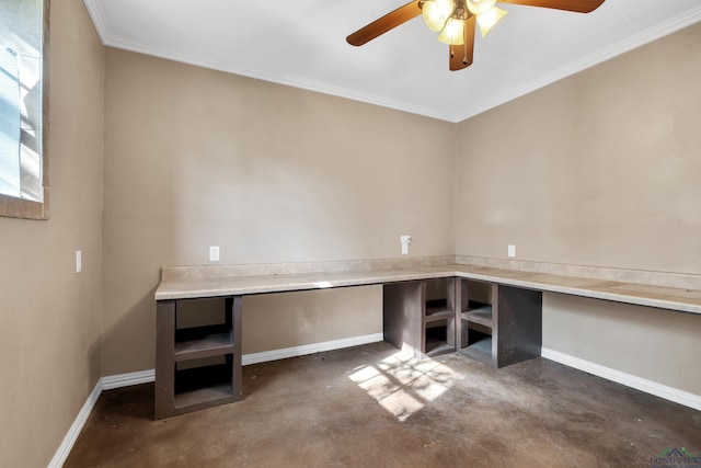 unfurnished office with ceiling fan, built in desk, concrete flooring, and crown molding