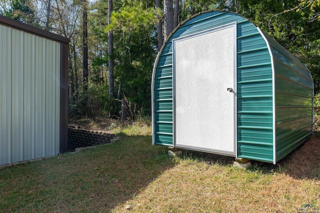 view of outbuilding featuring a lawn