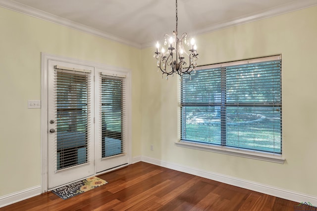 unfurnished dining area with crown molding, dark wood-type flooring, and a notable chandelier