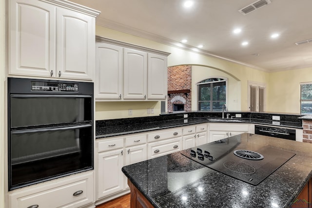 kitchen with kitchen peninsula, white cabinetry, sink, and black appliances