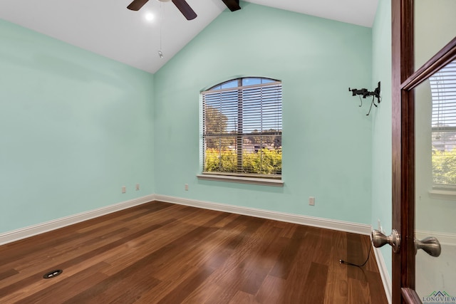 spare room with a wealth of natural light, ceiling fan, lofted ceiling with beams, and wood-type flooring