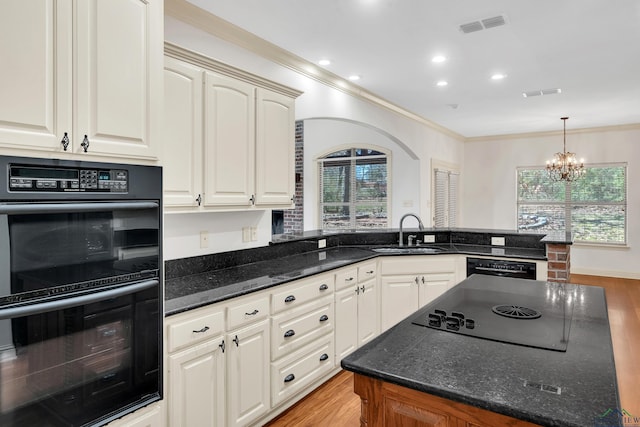 kitchen with ornamental molding, a chandelier, black appliances, visible vents, and a sink