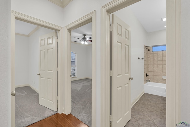 hallway with crown molding and baseboards