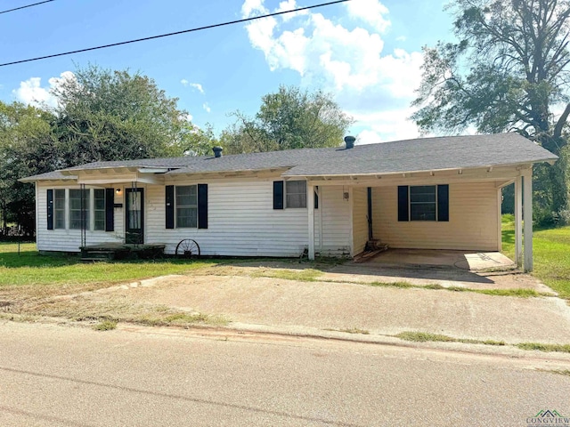 ranch-style house featuring a front lawn and a carport