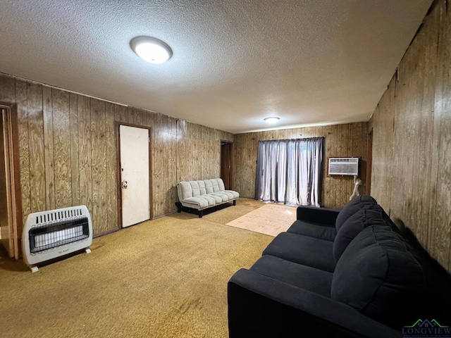 living room with heating unit, a wall mounted air conditioner, light colored carpet, and a textured ceiling