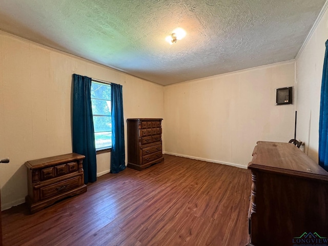 bedroom featuring crown molding, dark hardwood / wood-style floors, and a textured ceiling