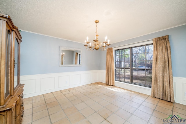 unfurnished room with a textured ceiling, an inviting chandelier, light tile patterned flooring, and crown molding