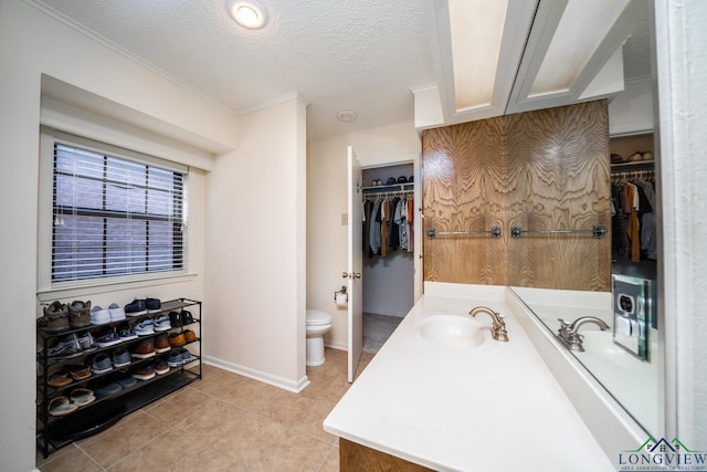 bathroom with tile patterned floors, a textured ceiling, toilet, and vanity