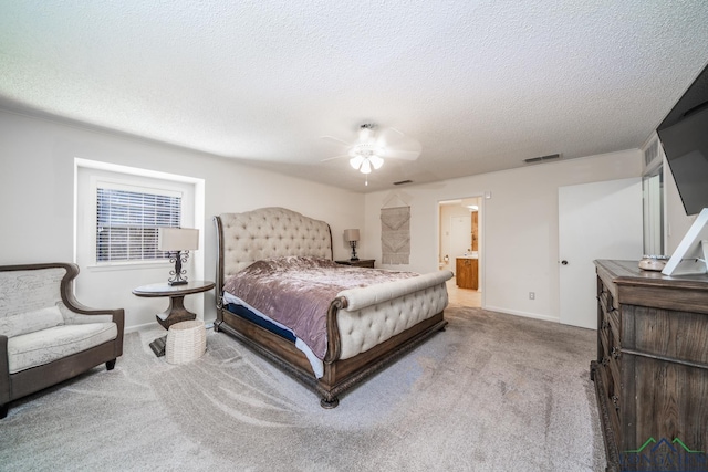 carpeted bedroom featuring ceiling fan, a textured ceiling, and ensuite bath