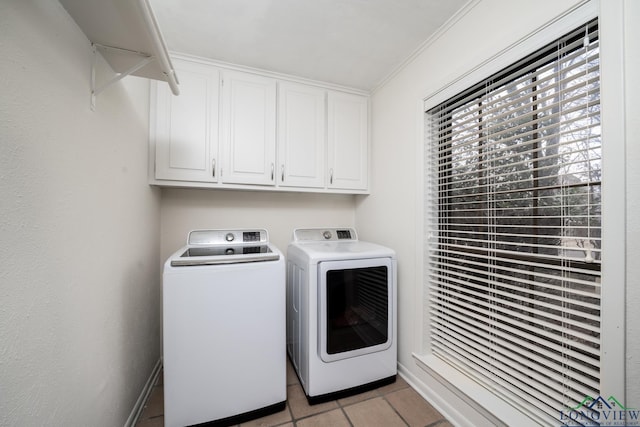 laundry area featuring cabinets, light tile patterned floors, ornamental molding, and independent washer and dryer