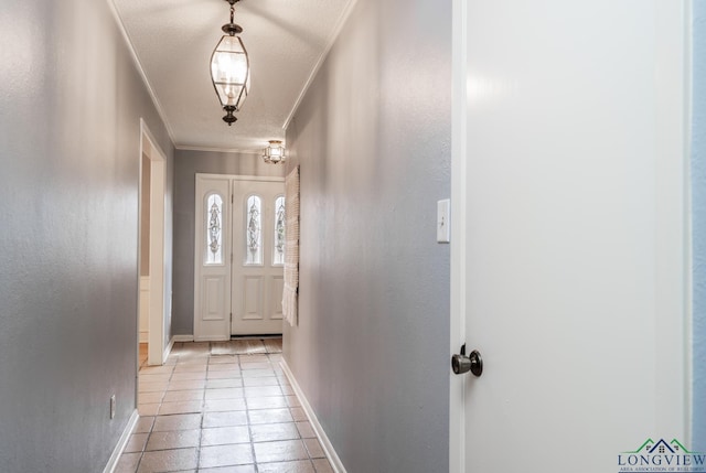 doorway to outside featuring light tile patterned floors, ornamental molding, and a textured ceiling