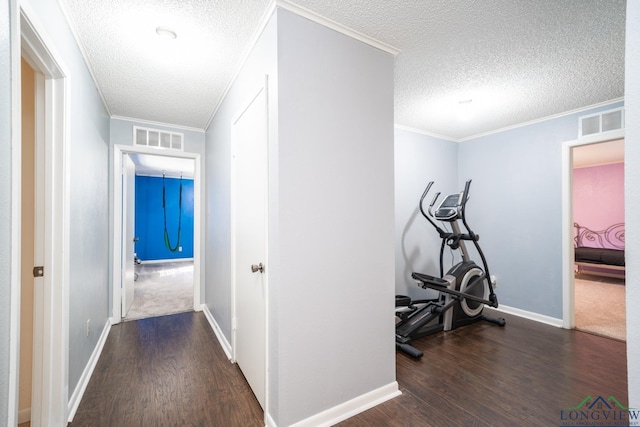 corridor with dark hardwood / wood-style floors, crown molding, and a textured ceiling