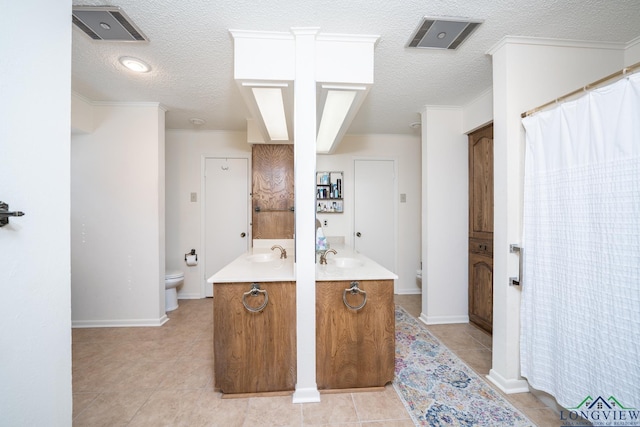 bathroom with toilet, a textured ceiling, tile patterned floors, and vanity