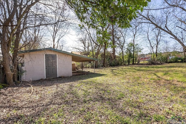 view of yard featuring a carport and an outdoor structure