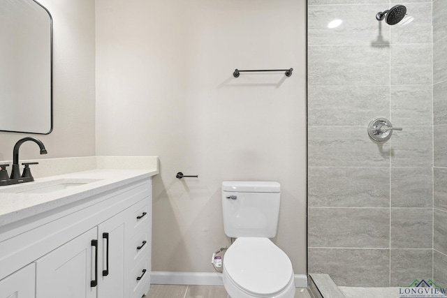 full bath featuring tiled shower, vanity, and toilet