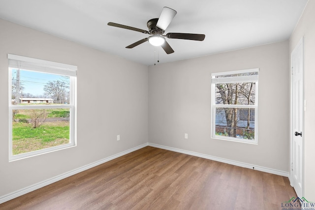 empty room featuring a ceiling fan, baseboards, and wood finished floors