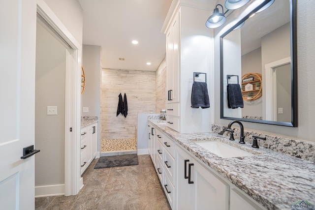 bathroom featuring tiled shower and vanity