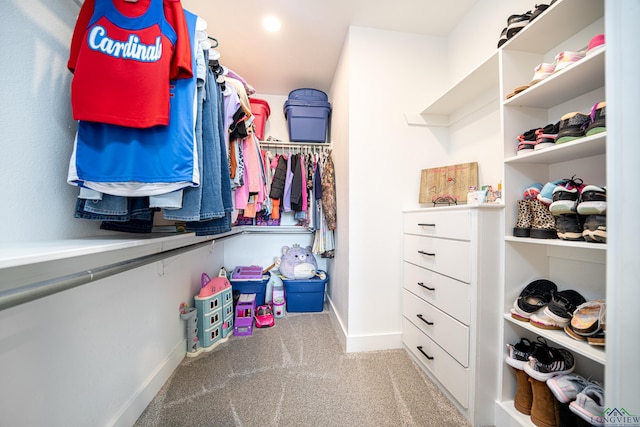 walk in closet with light colored carpet