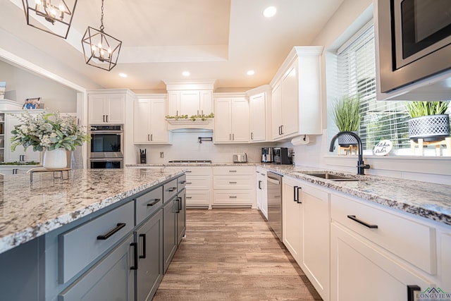 kitchen with pendant lighting, white cabinets, gray cabinets, a notable chandelier, and stainless steel appliances