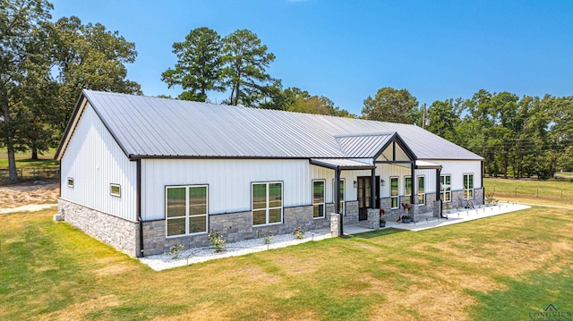 rear view of house featuring a patio and a lawn