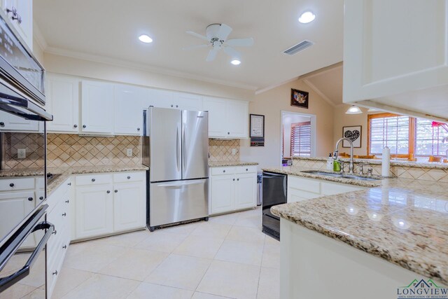 kitchen featuring ornamental molding, freestanding refrigerator, a ceiling fan, visible vents, and a sink