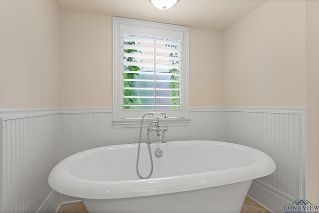 1312 Enchanted Ln, Longview, TX 75604 - bathroom featuring wainscoting and a soaking tub
