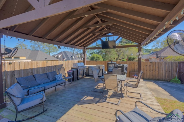 wooden terrace with a gazebo, area for grilling, a fenced backyard, outdoor dining area, and an outdoor hangout area
