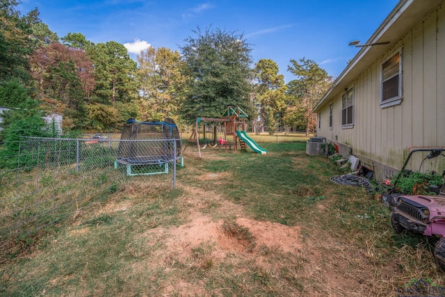 view of yard featuring a playground, cooling unit, and a trampoline